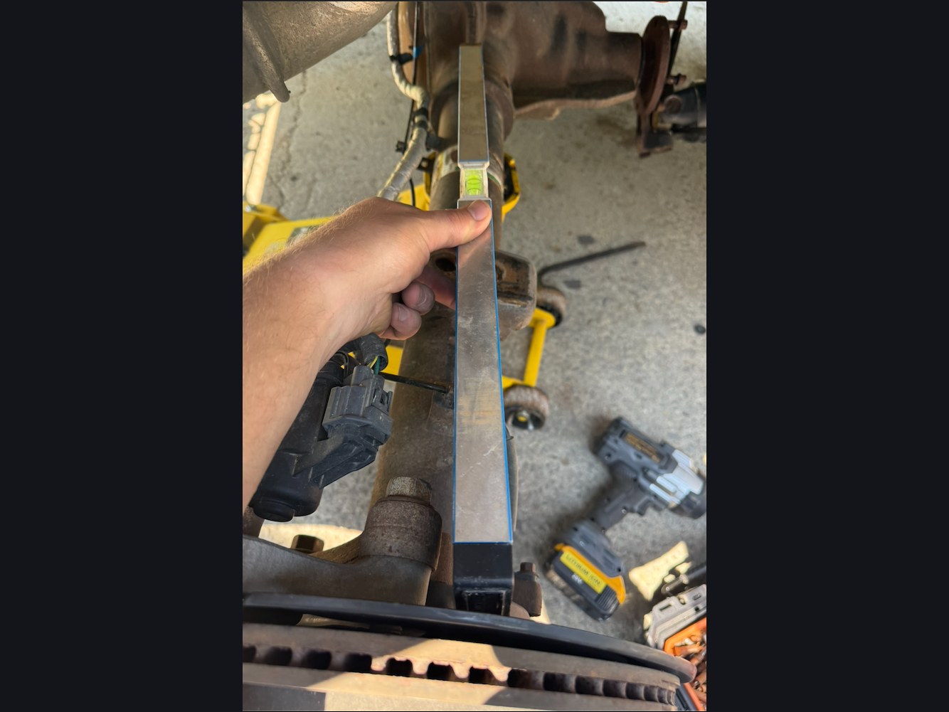 Ford (OEM, used) Replacement rear axle assembly, used donor — The axle it replaced: a straightedge along the original housing shows the bend.
